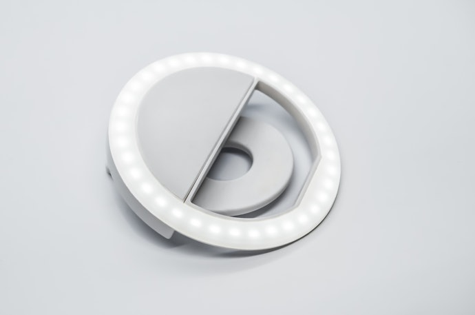 Untuk selfie, gunakan ring light mini yang dipasangkan ke HP dengan klip
