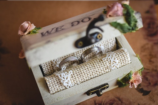 Untuk konsep rustic dengan kesan hangat dan natural, pilih tempat cincin kayu atau rotan yang dihiasi bunga kering