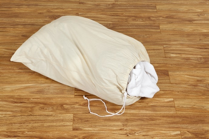 Utamakan tas laundry yang bisa dilipat kecil dan ditutup rapat untuk traveling
