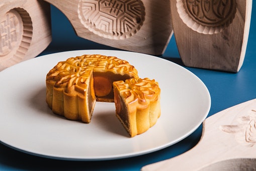 Kue bulan warna cokelat: Tekstur kuenya lebih lembut dan ada ukiran artistik