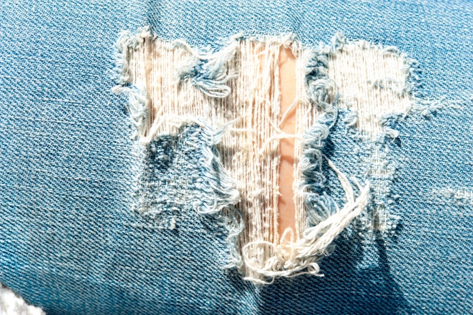 Ripped jeans dengan shreds, tampilan stylish masa kini