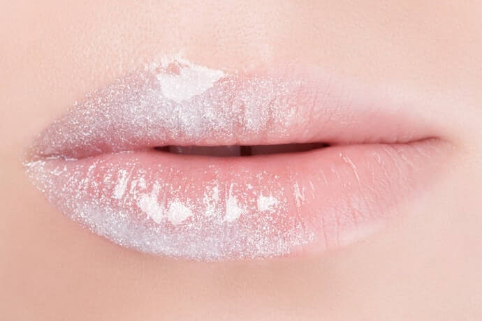 Lip gloss dengan efek glitter, pas untuk riasan yang lebih glamor